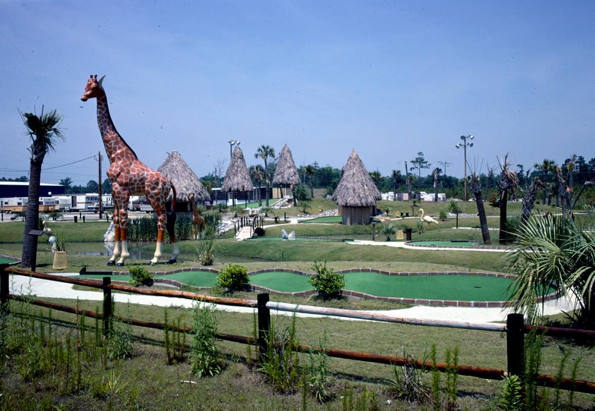 Historic Photo : 1979 Overall and giraffe, Tropical Village mini golf, Surfside Beach, South Carolina | Margolies | Roadside America Collection | Vintage Wall Art :