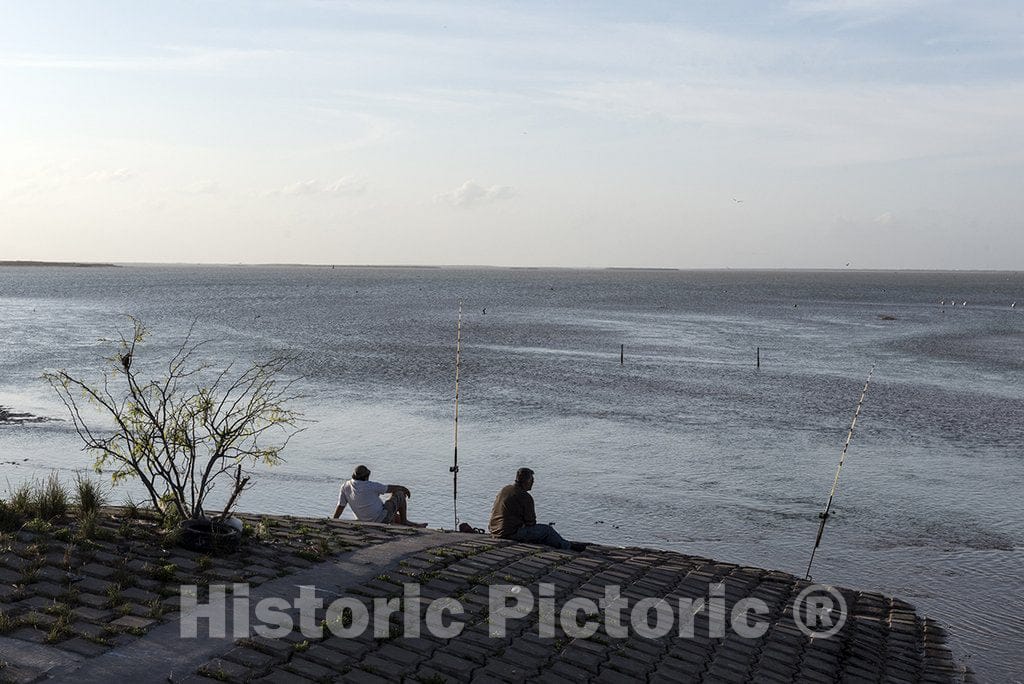 Brownsville, TX Photo - Fishermen wait for a bite along South Bay, below the long causeway that connects Brownsville and Port Isabel in Cameron County, Texas