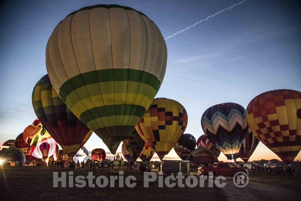 Colorful balloons delight the assembled crowd with a night glow as pilots fire the burners on the ground at the National Balloon Classic,  5