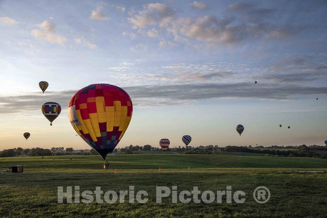 Colorful balloons delight the assembled crowd with a night glow as pilots fire the burners on the ground at the National Balloon Classic,  7